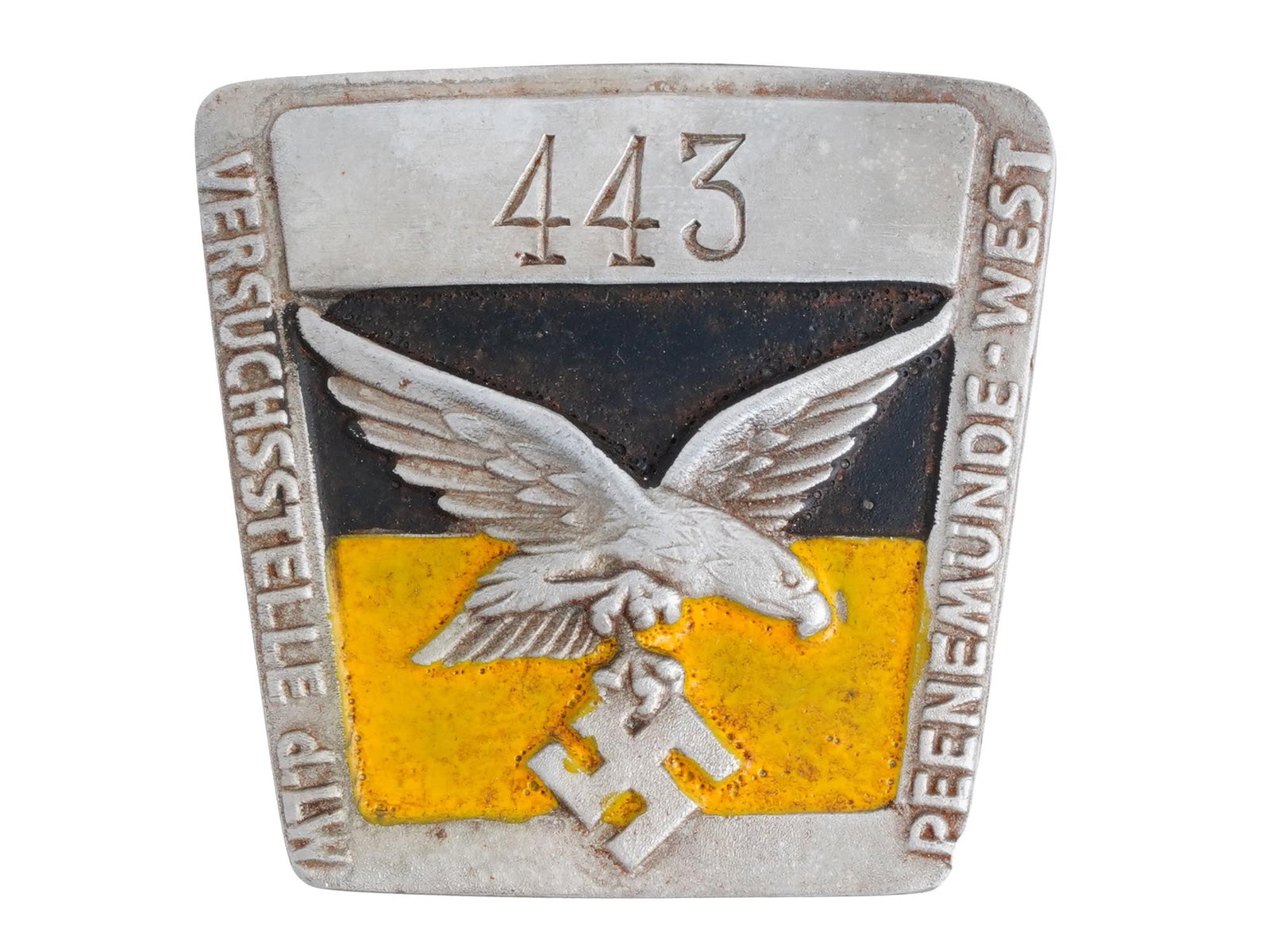 NAZI GERMAN WWII PEENEMUNDE V2 FACTORY CAMP BADGE: A WWII Nazi German Third Reich Luftwaffe Peenemunde West V 2 factory employee concentration camp metal badge. The badge is decorated with an engraved eagle swastika insignia, covered with enamel in bl