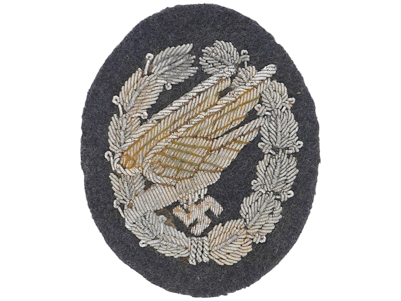 WWII GERMAN LUFTWAFFE PARATROOPER EMBROIDERED BADGE: A WWII German military Luftwaffe Paratrooper Embroidered Cloth Badge. The Parachutist Badge was a badge awarded to qualified parachutists of the Wehrmacht and the Waffen SS of Nazi Germany. The badge 