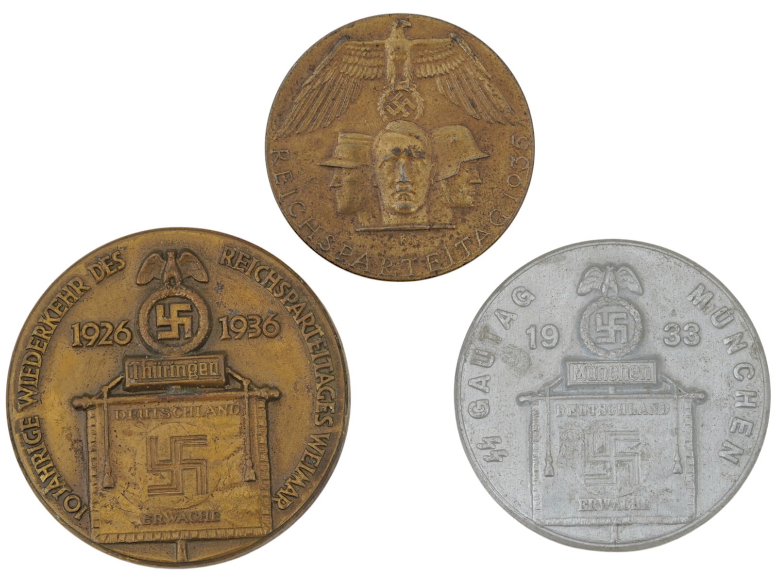 LOT OF WWII MODEL NAZI GERMAN NSDAP AND SS BADGES: A lot of three WWII model Nazi German badges. The lot includes NSDAP Reichsparteitag 1935 Tinnie badge; NSDAP Reichsparteitag Weimar Badge 1926 to 1936 Weimar 10 Year; SS Gautag Munchen 1933 badge. Ea