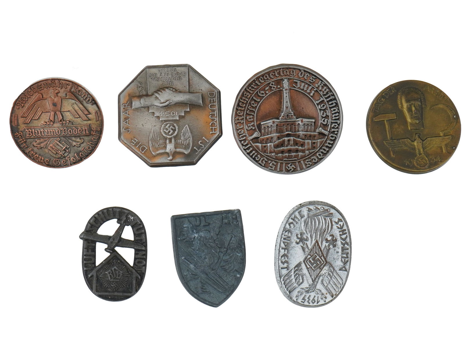WWII NAZI GERMAN PROPAGANDA COMMEMORATIVE PIN BADGES: A collection of pre-WWII and WWII Nazi German propaganda and commemorative pin badges. Included are Deutsch Ist Die Saar 1934 badge, Reichskriegertag des Kyffhauserbundes 1935 badge, Tag der Arbeit 19