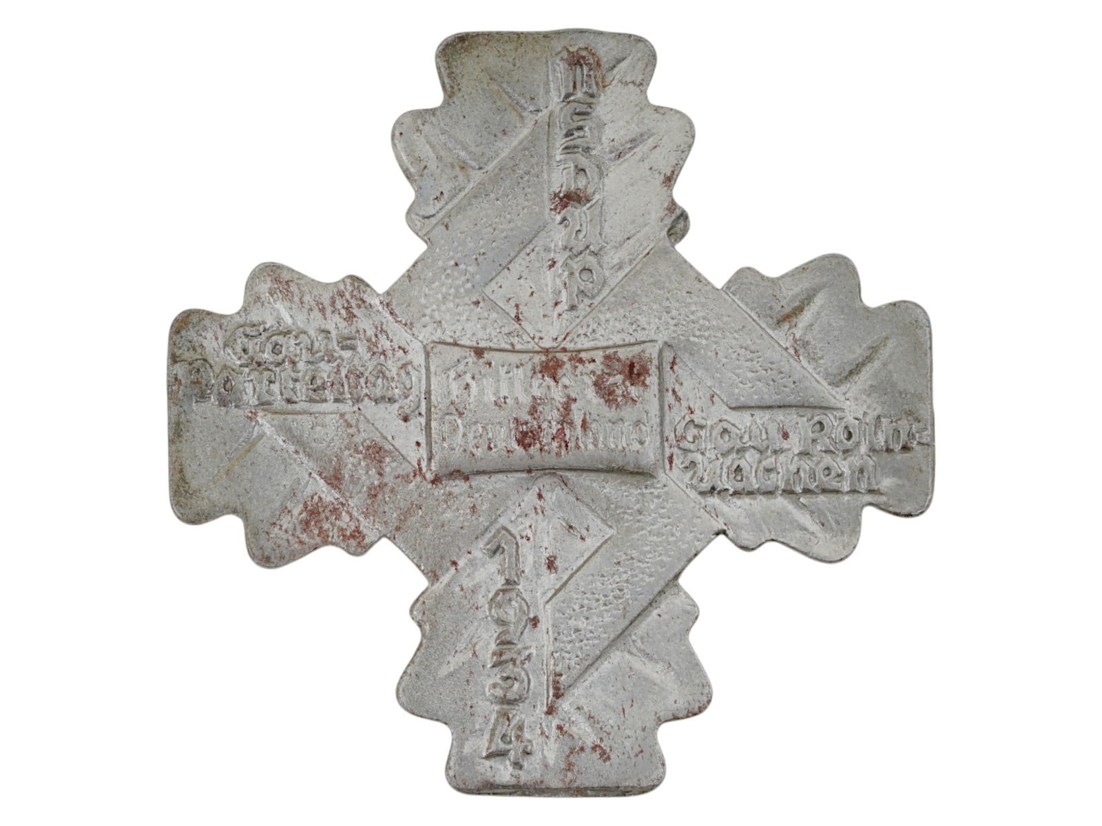 WWII GERMAN GAU KOLN AACHEN PARTEITAG TINNIE 1934 BADGE: A WWII era German Gau Koln Aachen Parteitag Tinnie 1934 badge. A cross made in the shape of four oak leaves with a relief swastika on it. Inscribed NSDAP Gau Parteitag Koln Aachen 1934. In the middle