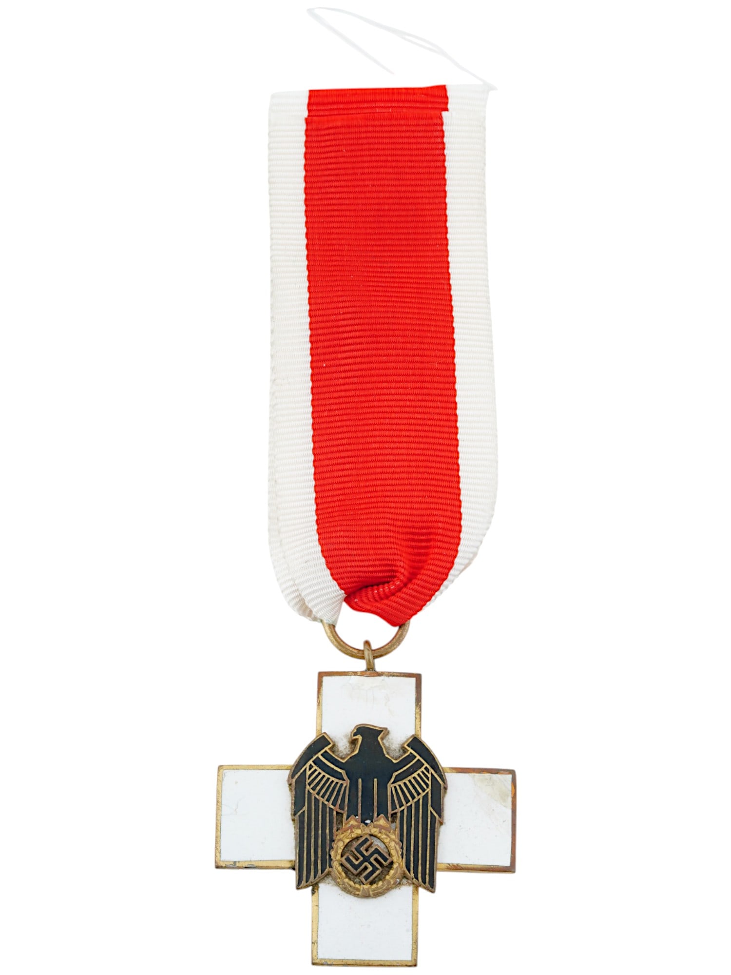 WWII NAZI GERMAN SOCIAL WELFARE BADGE DECORATION: A WWII Nazi German Social Welfare badge decoration, 3rd class. The award is a gold tone cross covered with white enamel, featuring a superimposed emblem of a Reichsadler eagle holding a swastika, cove