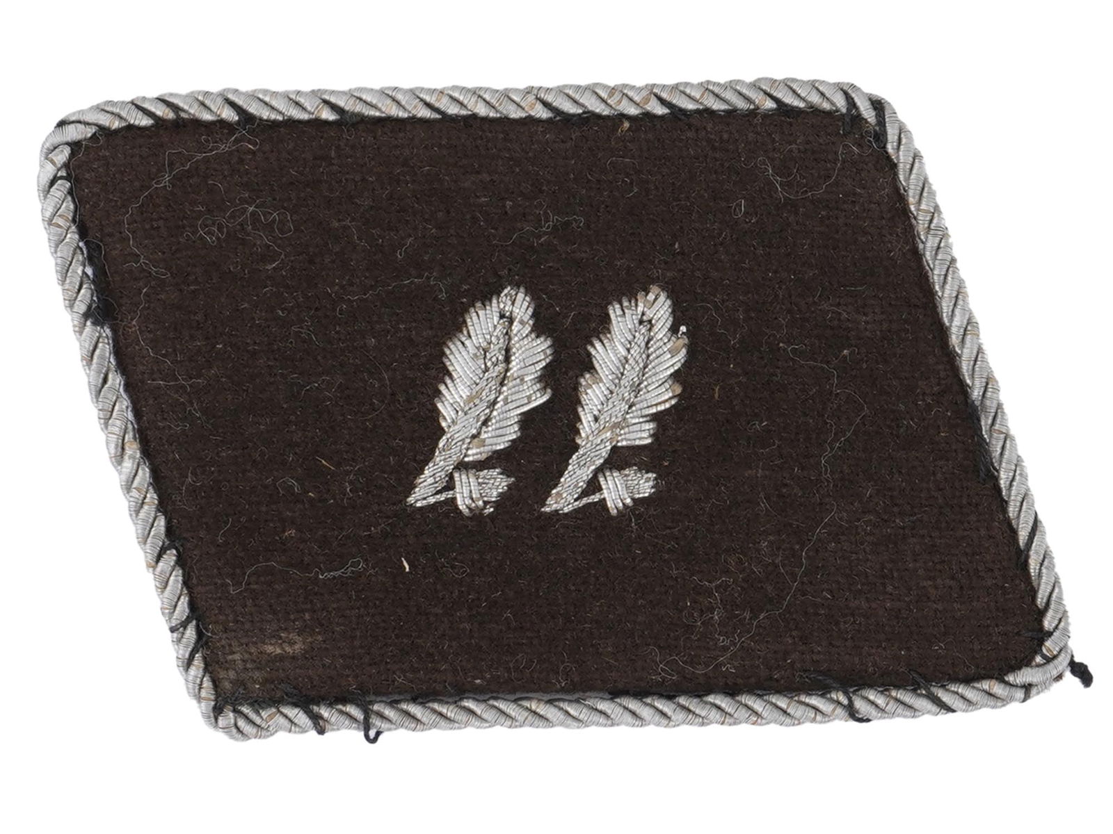 WWII NAZI GERMAN WAFFEN SS UNIFORM COLLAR TAB: A WWII model Nazi German Waffen SS uniform collar tab. Black wool with zinc overlay depicting two oak leaves with two acorns. Silver tone piping. Second World War Historical Collectables And Memorabil