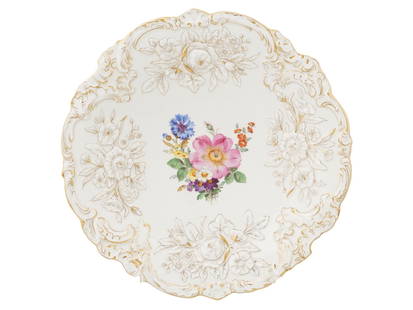 ANTIQUE MEISSEN GILT PORCELAIN SERVING PLATE: A late 19th-century porcelain serving plate by Meissen Porzellan, a prominent German porcelain manufacture. Round plate with figurative rim. Relief floral border with gilt accents. The center depicts