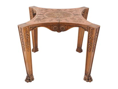 ANTQUE AMERICAN CARVED WOODEN TABLE W FLORAL DESIGN: An antque American carved wooden table. The table has a square tabletop with intricate carved details, including a central floral design. The table legs are carved with leafy patterns and end in claw