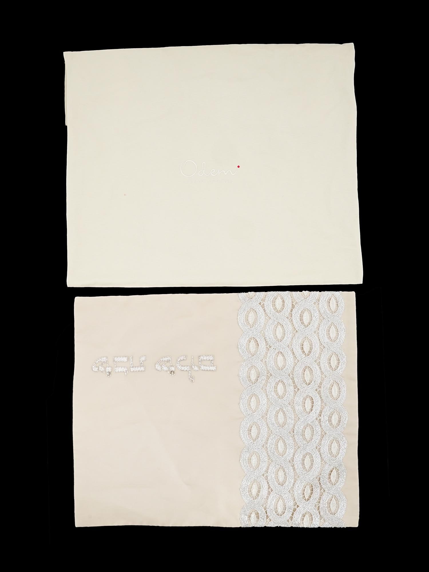 VINTAGE AMERICAN JUDAICA HANDMADE CHALLAH BREAD COVER: A vintage American Judaica challah bread cover, dating to the 20th century, handmade with lace details and embroidered Hebrew inscriptions. Includes a matching storage bag. Made by Odem, The Art of Ri