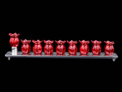 ISRAELI POMEGRANATE ENAMEL HANUKKAH MENORAH LAMP: A Contemporary enamel aluminum Hanukkah Menorah lamp. The lamp features a nine candle holders made in a pomegranate design, and covered with enamel in a red shade. Mounted on a footed rectangular shap