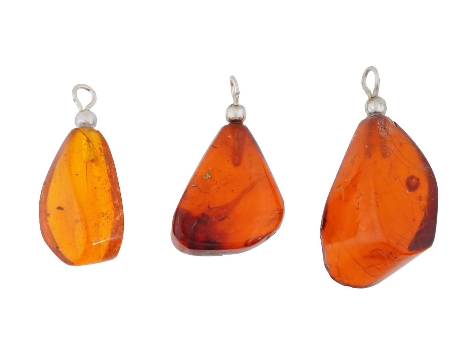 PREHISTORIC AMBER PENDANT WITH THREE INSECT INCLUSIONS: A prehistoric amber pendant containing three distinct insect inclusions, a beetle, a worker ant, and a biting midge, dating to approximately 12 million years ago. This natural specimen offers a rare g