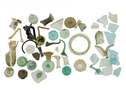 ANCIENT ROMAN BROKEN GLASS FRAGMENTS OF VARIOUS COLORS: A collection of mixed ancient Roman broken glass fragments, featuring various colors and pieces from vessels, including necks, handles, and stems. These fragments showcase the craftsmanship and vibran