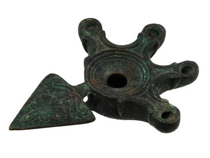 ANTIQUE ANCIENT ROMAN BRONZE GRAND TOUR OIL LAMP: An antique bronze Grand Tour oil lamp in the style of ancient Roman examples from the 2nd century AD, featuring four spouts. While modeled after classical antiquities, such pieces were produced betwee