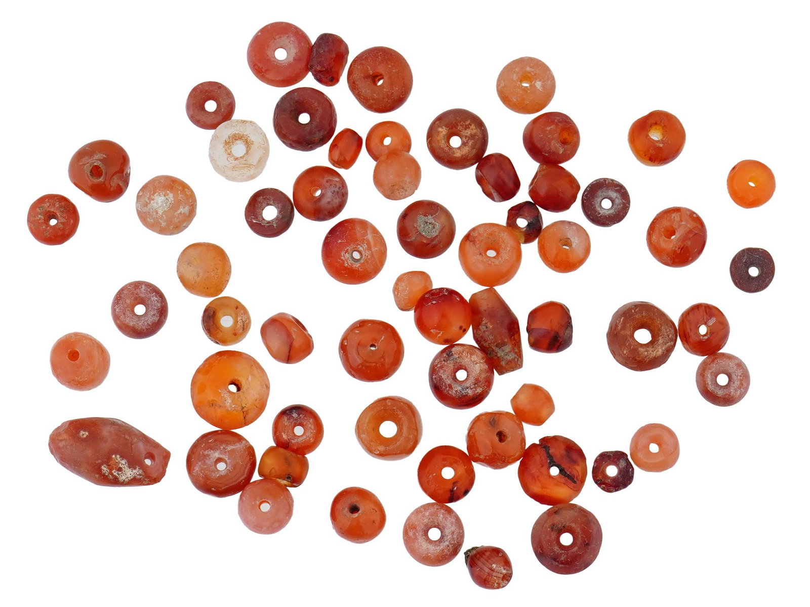 GROUP OF ANCIENT CARNELIAN BEADS 1ST MILLENNIUM: A group of ancient carnelian beads dating to the 1st millennium, likely originating from the Near East or South Asia. These hand-carved beads display the deep reddish-orange hues characteristic of car