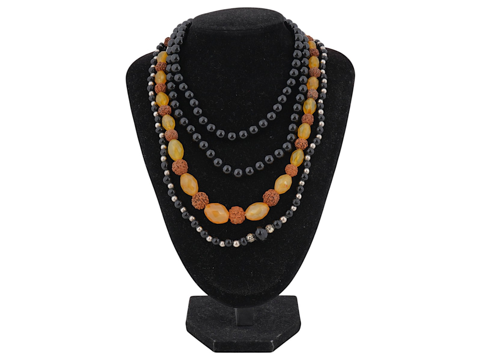 COLLECTION OF NECKLACES WITH CARVED STONE BEADS: A collection of carved stone necklaces featuring beads of various sizes, shapes, and colors. Some of the beads are already assembled into necklaces, while others are strung on temporary strings, offer