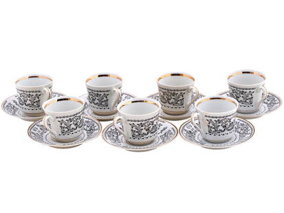POLISH BOGUCICE PORCELAIN TEACUPS AND SAUCERS: A lot of vintage Polish porcelain teacups and saucers by Bogucice. Ca. 1952 to 1993. A total of 7 identical tea pairs. White pieces with black transfer-printed ornaments and gilt rims. B Made in Polan