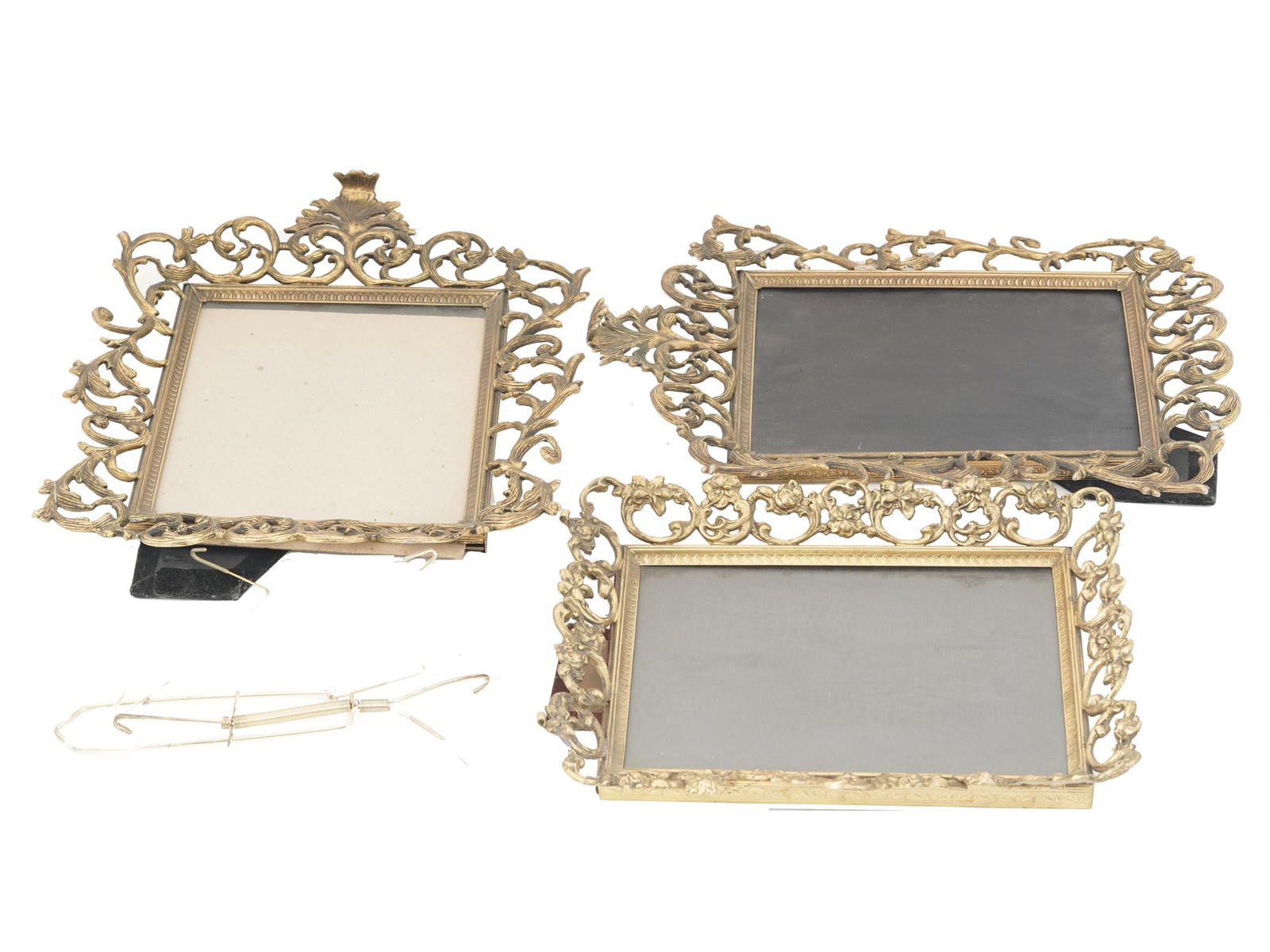 COLLECTION OF THREE BRONZE PICTURE PHOTO FRAMES: A collection of three bronze photo or picture frames. The frames are adorned with figural Victorian style borders made in the shape of leaves and scrollwork patterns. Each frame with a stand on the ba