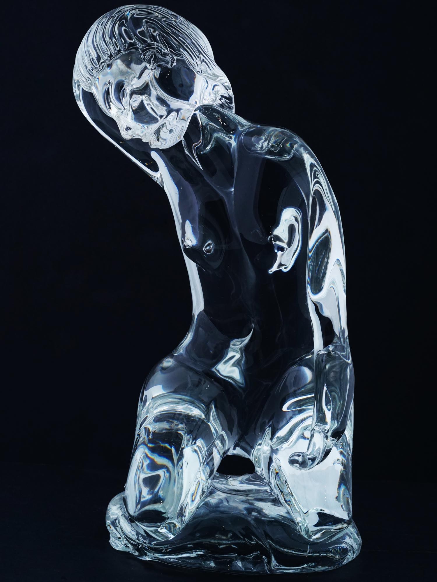 VINTAGE KOSTA BODA ART GLASS FEMALE NUDE SCULPTURE: A vintage cut transparent glass sculpture by Kosta Boda, a Swedish glassware company established in 1742. The artwork represents a seated nude woman. Presumably designed by Loredano Rosin, 1936 to 199