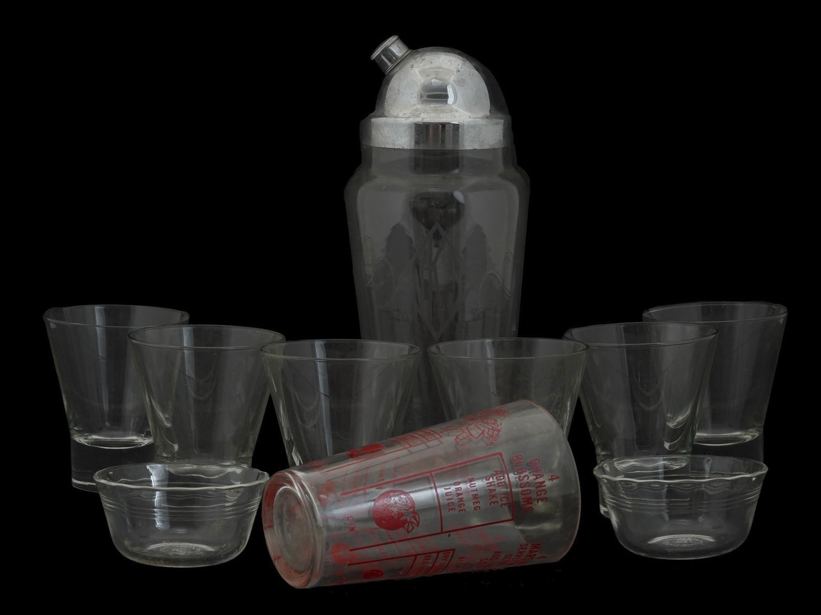 MID CENTURY MODERN BARWARE SET WITH MIXER MEASURE: A mid century modern barware set including a crystal glass cocktail shaker with a chromium lid and etched WKS monogram, a bar cocktail mixer measure, two Pyrex glass bowls, shot glasses with heavy bot