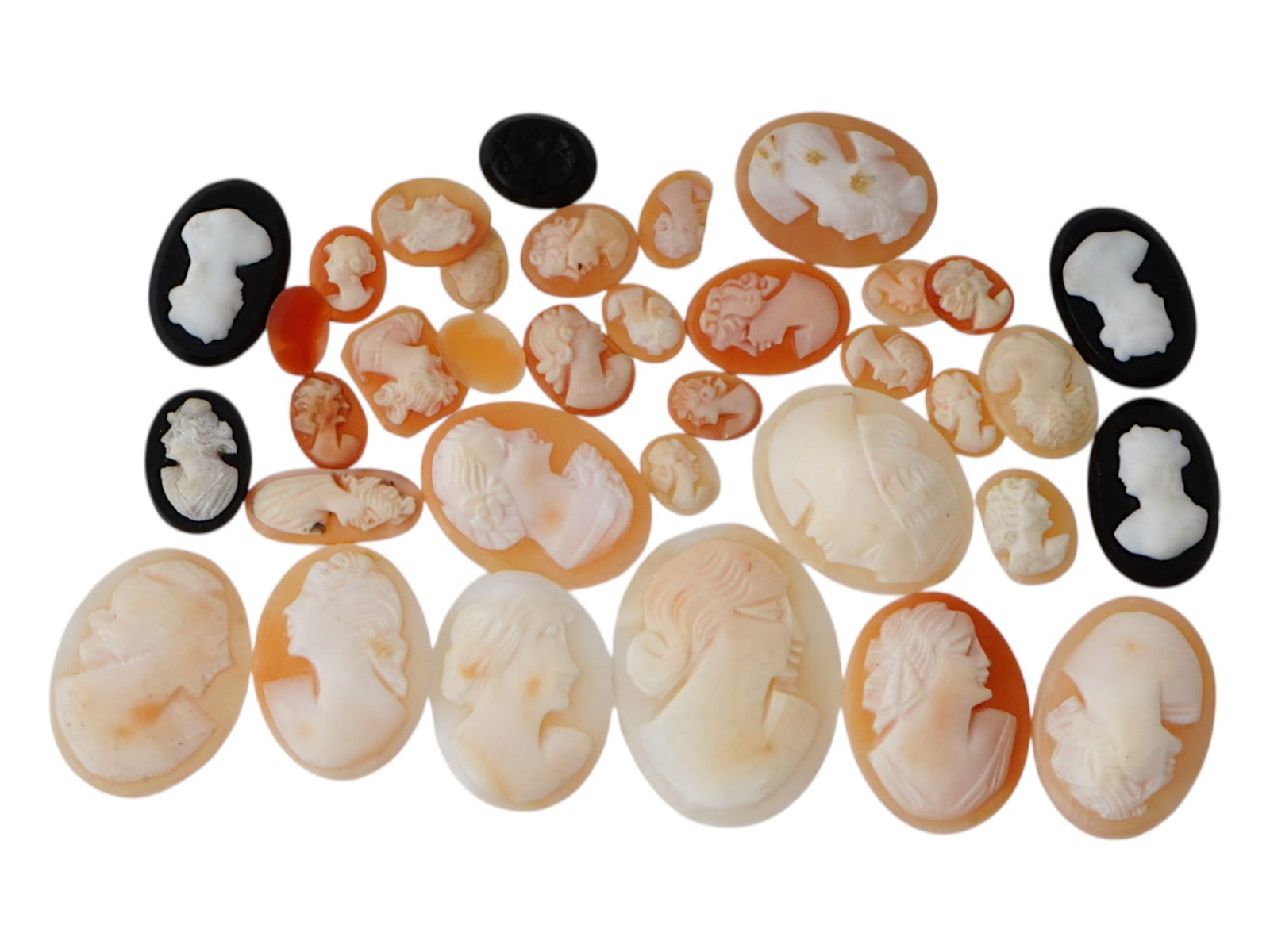 COLLECTION OF ANTIQUE HAND CARVED CAMEOS: A collection of antique hand carved cameos, dating to the late 19th to early 20th century. A total of 35 items. Each piece is crafted from conch shell, featuring female portraits rendered in high reli