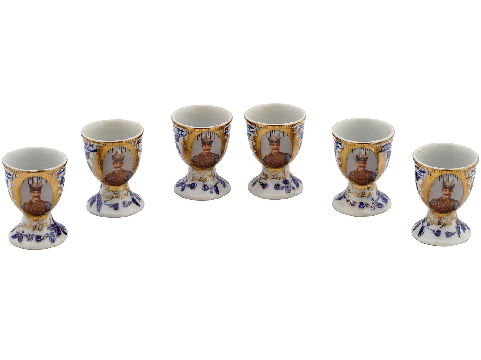 1970S PERSIAN NASER AL-DIN PORCELAIN EGG CUPS: A set of six vintage fine quality porcelain egg cups, Japanese porcelain, for the Persian Market. Custom made for a wedding present in Persia, the written text is: For Houshang Talasazan. Circa 1970.