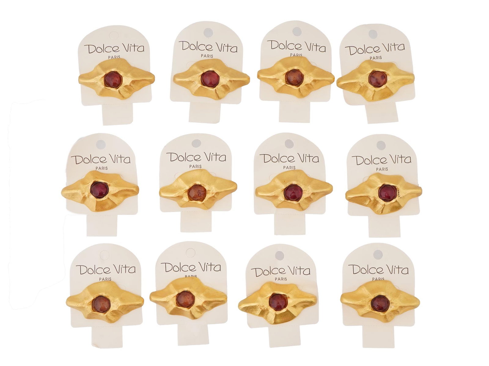 VINTAGE FRENCH DOLCE VITA COSTUME JEWELRY BROOCHES: A vintage French Dolce Vita costume jewelry set, including 12 brooches. The brooches have a stylized, abstract design with a central dark red colored stone and a textured gold toned metal surrounding 