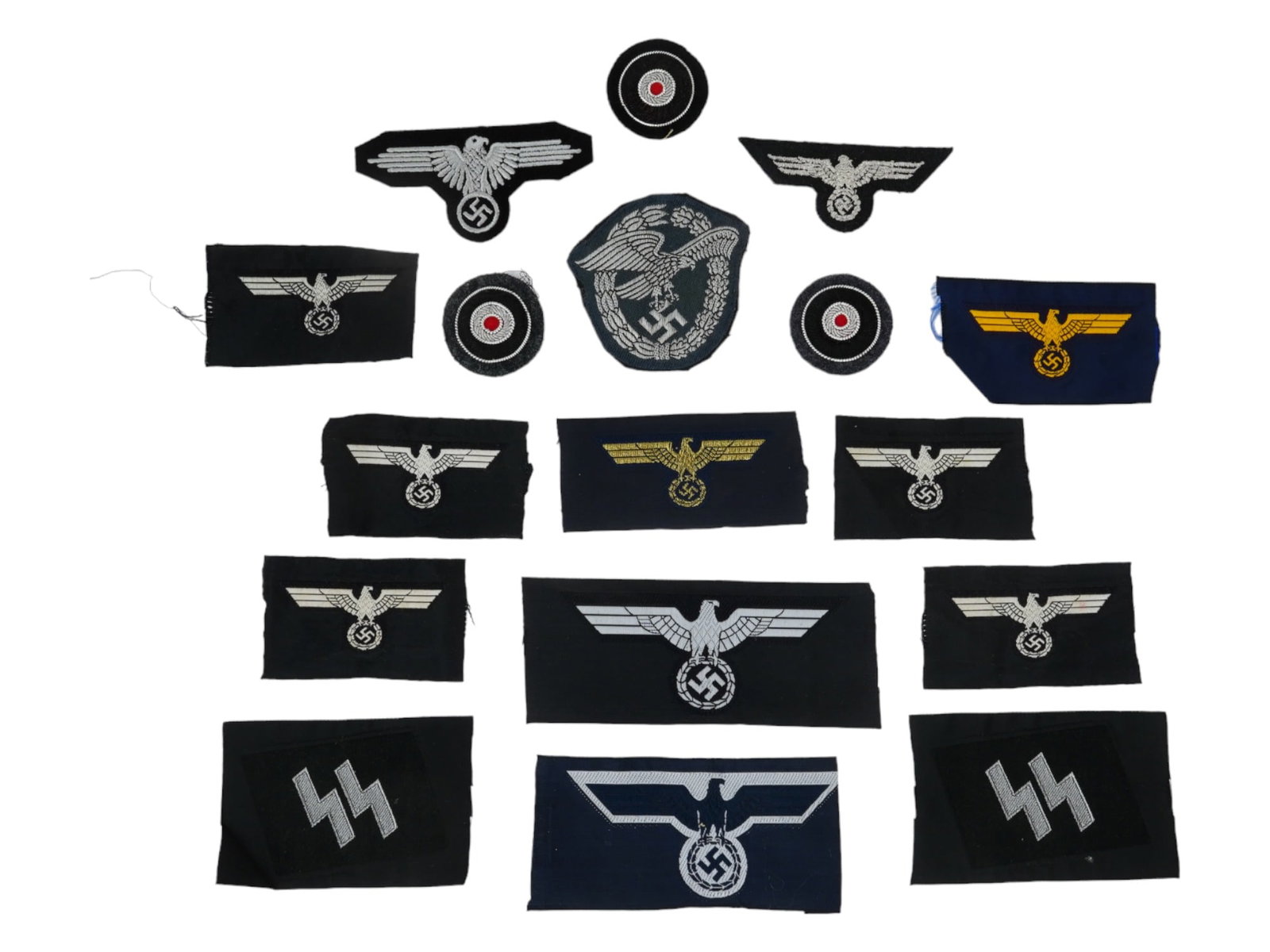 COLLECTION OF NAZI GERMANY FABRIC PATCHES 17 ITEMS: A large collection of Nazi Germany fabric patches, a total of 17 items. The lot includes 11 Wehrmacht eagle patches in white and yellow, 3 headdress patches with red dots, 2 SS chevrons. 1 Luftwaffe e