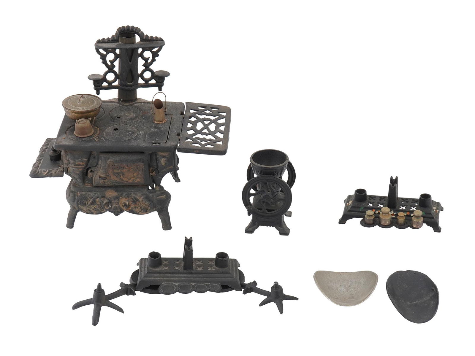 VINTAGE MINIATURE CAST IRON KITCHEN SET: A vintage miniature kitchen set, including a cast iron stove made by Crescent with an ornate design, a coffee grinder, a spice rack, a hot water kettle and other wares. Vintage Kitchenware Tableware C