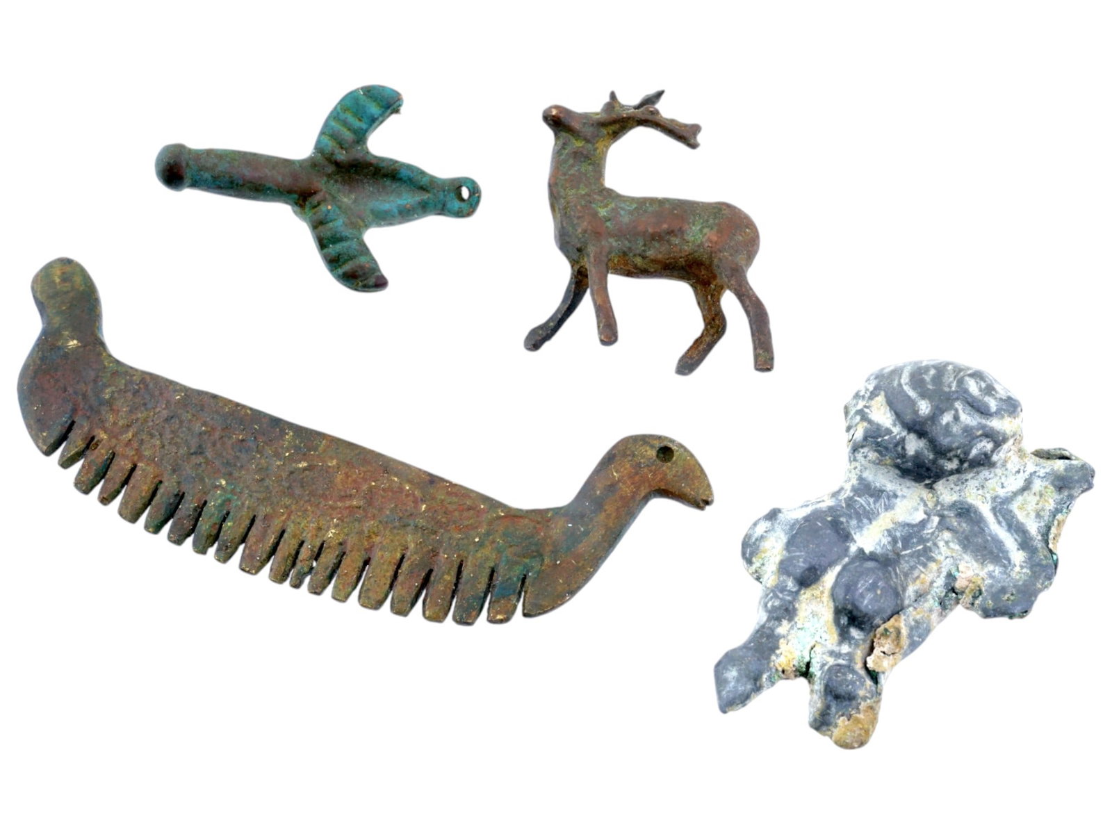 GROUP OF FOUR ANCIENT METAL ARTIFACTS: A group of four ancient artifacts: a small, stylized erotic winged figurine pendant, a standing deer figurine, a comb with a handle shaped like a birds head, and a sculptural fragment. Collectible Arc