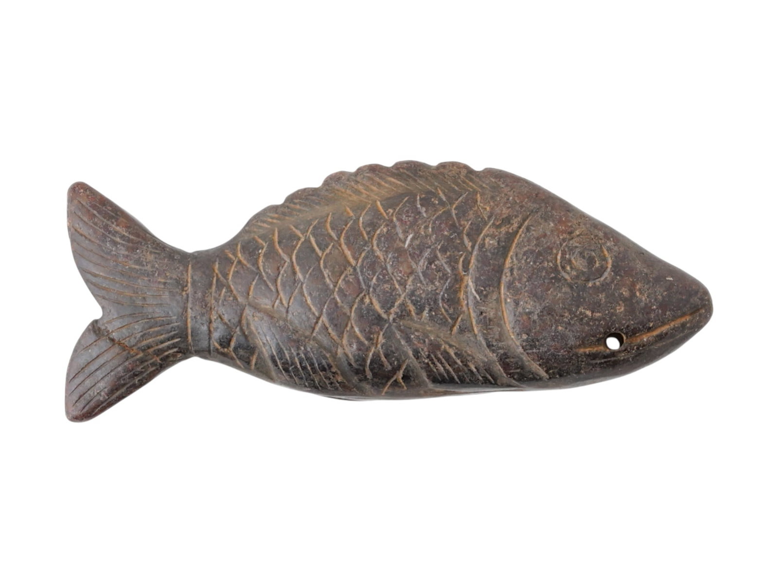 ANCIENT EGYPTIAN PTOLEMAIC CARVED STONE FISH PENDANT: An ancient Egyptian stone fish pendant from the Ptolemaic Period, from 305 to 30 BC, carved with distinctive button-like eyes and pierced for suspension, likely worn as an amulet or decorative persona