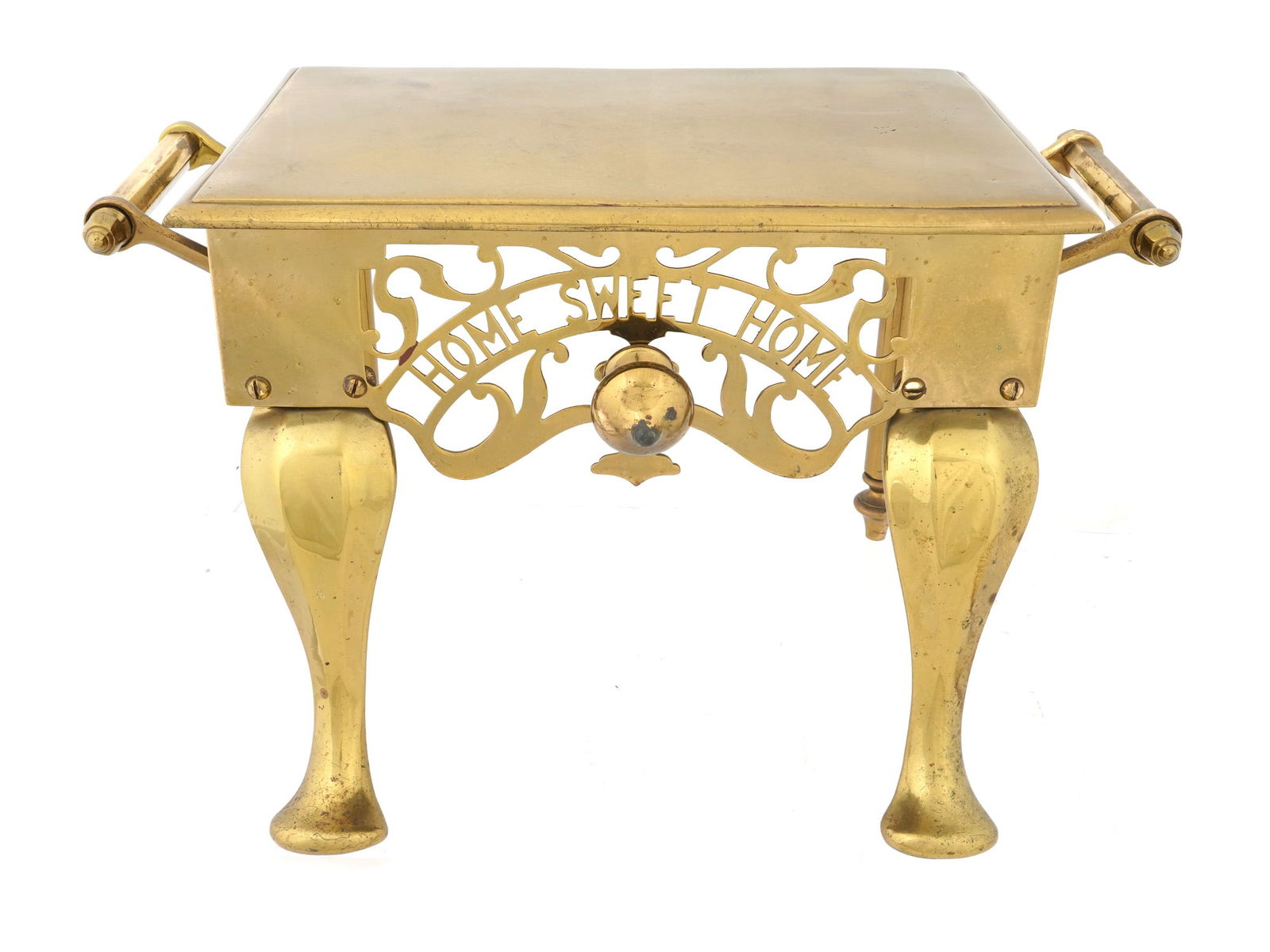 ANTIQUE ENGLISH BRASS FIREPLACE TRIVET OTTOMAN: An antique English brass fireplace trivet ottoman. Circa the late 19th century. The item is modeled in the form of a small table in gold tone with two handles on the sides and figured legs. Under the