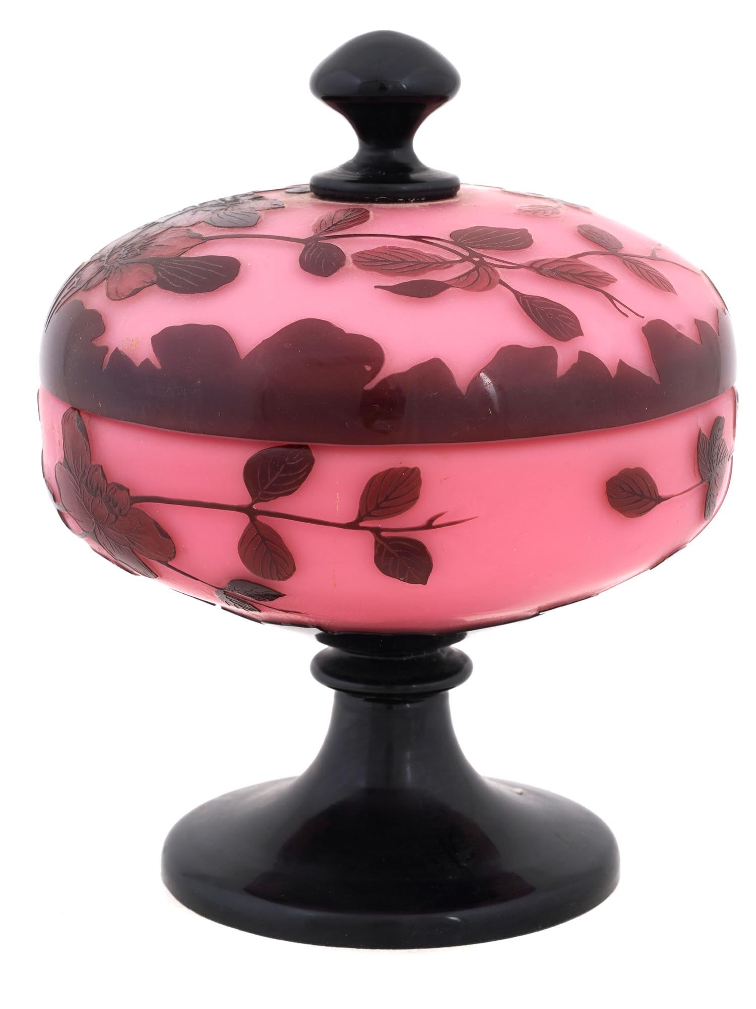20TH C CANDY BOWL W LID AND FLOWER DECOR SIGNED LOETZ: A 20th century candy bowl with a lid by Loetz manufacturer. The bowl has a pink glass body with a dark red overlay decoration of leaves and flowers around the exterior. The candy bowl has a black glas