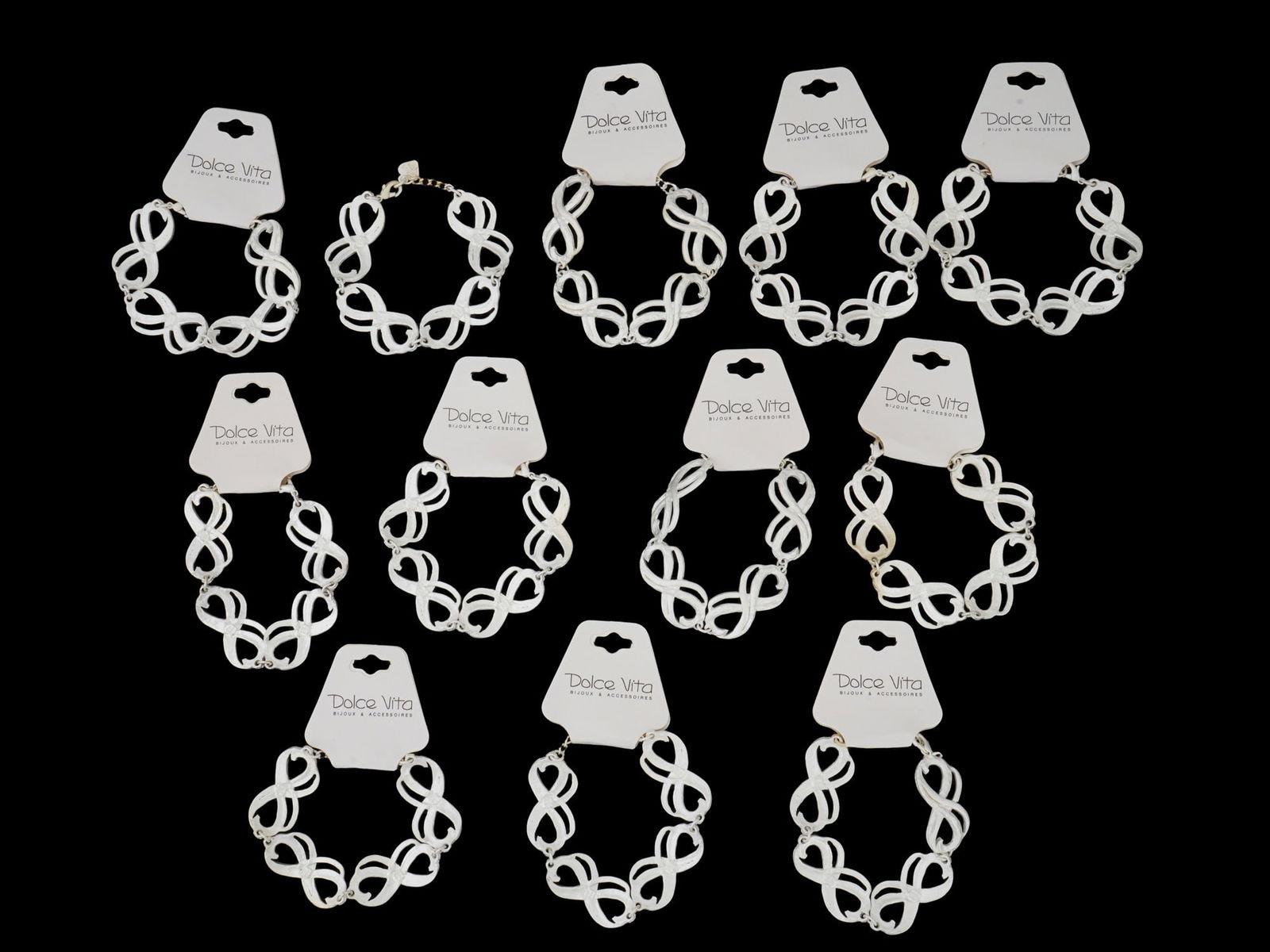 LOT OF FRENCH DOLCE VITA LINK BRACELETS: A lot of vintage French Dolce Vita costume jewelry, a total of 12 silver-tone link bracelets. Ca. 1980s. Original labels are preserved. The links are shaped as the infinity symbol. Dolce Vita was a je