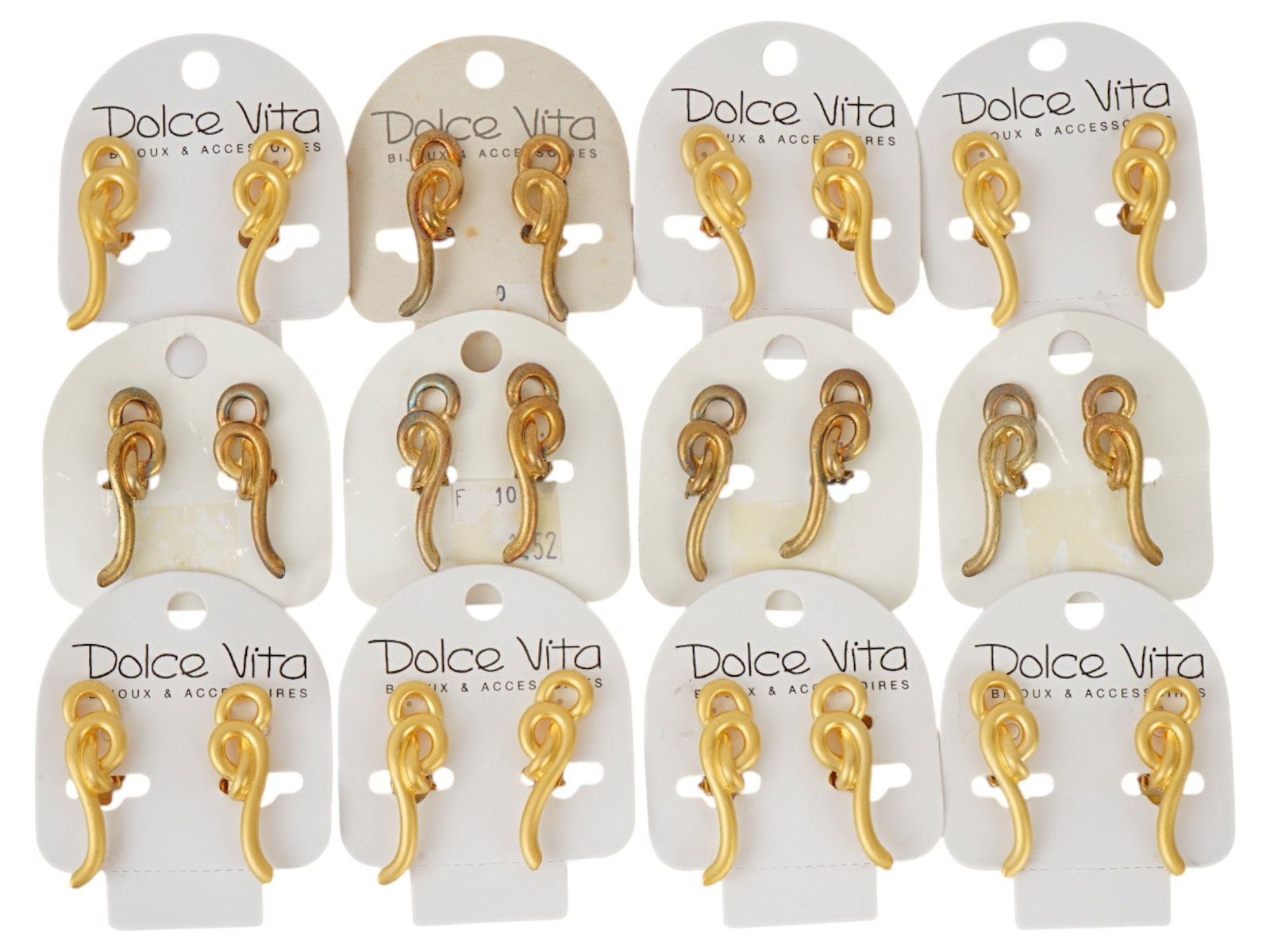 FRENCH DOLCE VITA COSTUME JEWELRY CLIP EARRINGS: A collection of twelve pairs of French Dolce Vita costume jewelry clip earrings. Each ware is made in the abstract design reminiscent of a gilt rope tied in a knot. Displayed on white cardboard cards,