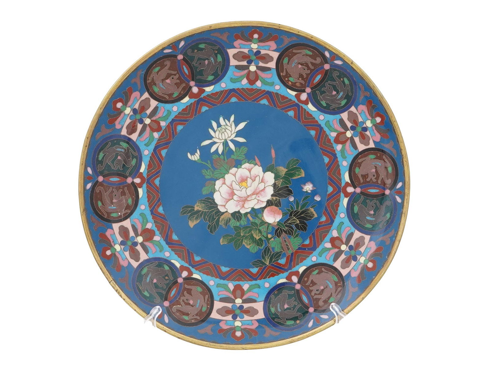 ASIAN FLORAL POLYCHROME CLOISONNE ENAMEL PLATE: An Asian probably Japanese polychrome enamel plate. The plate is adorned with a polychrome enamel design representing blossoming flowers surrounded by medallions with Foo dogs, floral, foliage and geo
