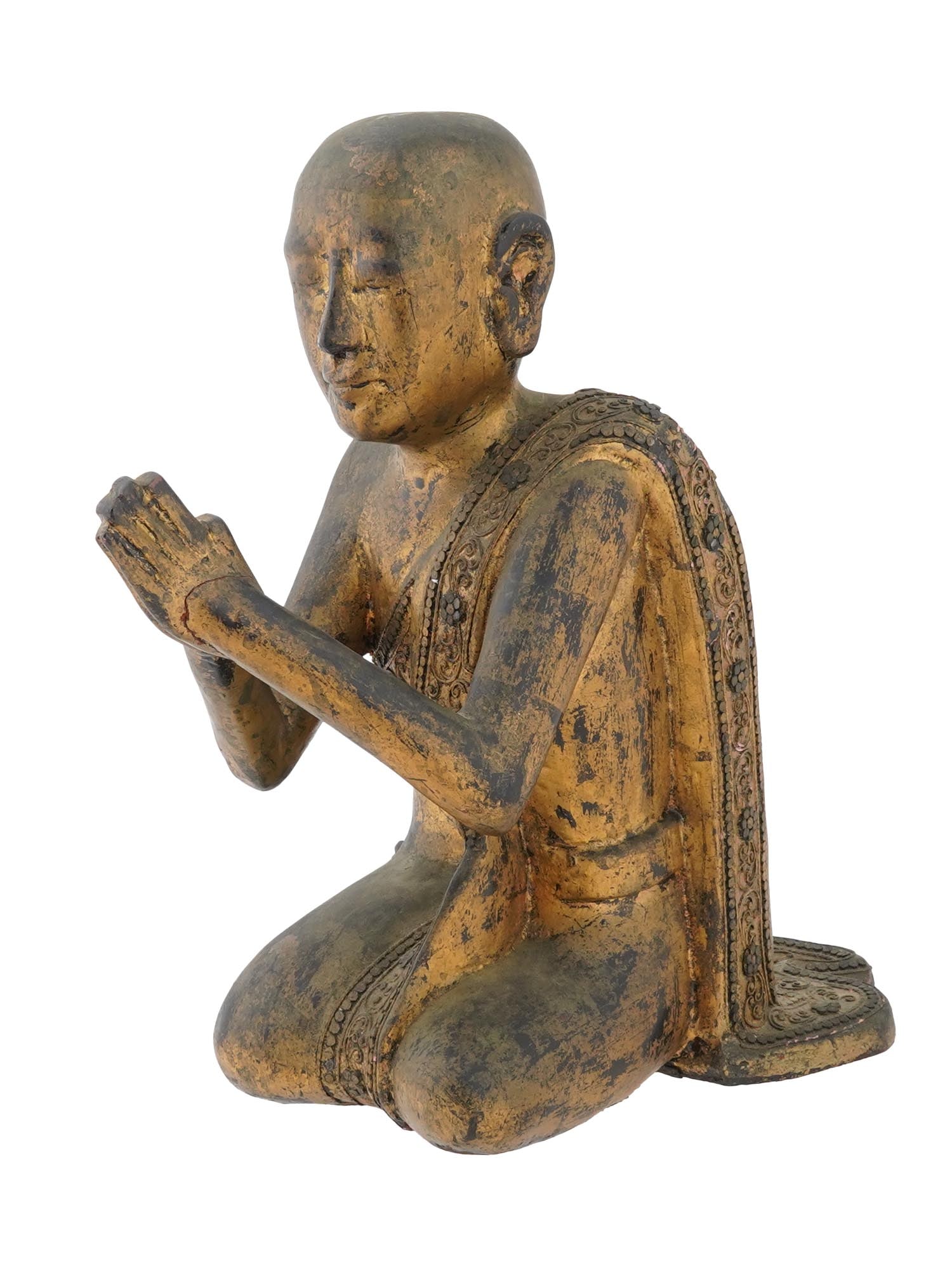 ANTIQUE CARVED WOODEN FIGURINE OF BURMESE BUDDHIST MONK: An antique Asian hand carved wooden figurine of a Burmese Buddhist monk in a seated position. The figure is bald-headed, with closed eyes and hands pressed together in a gesture of prayer or greeting.