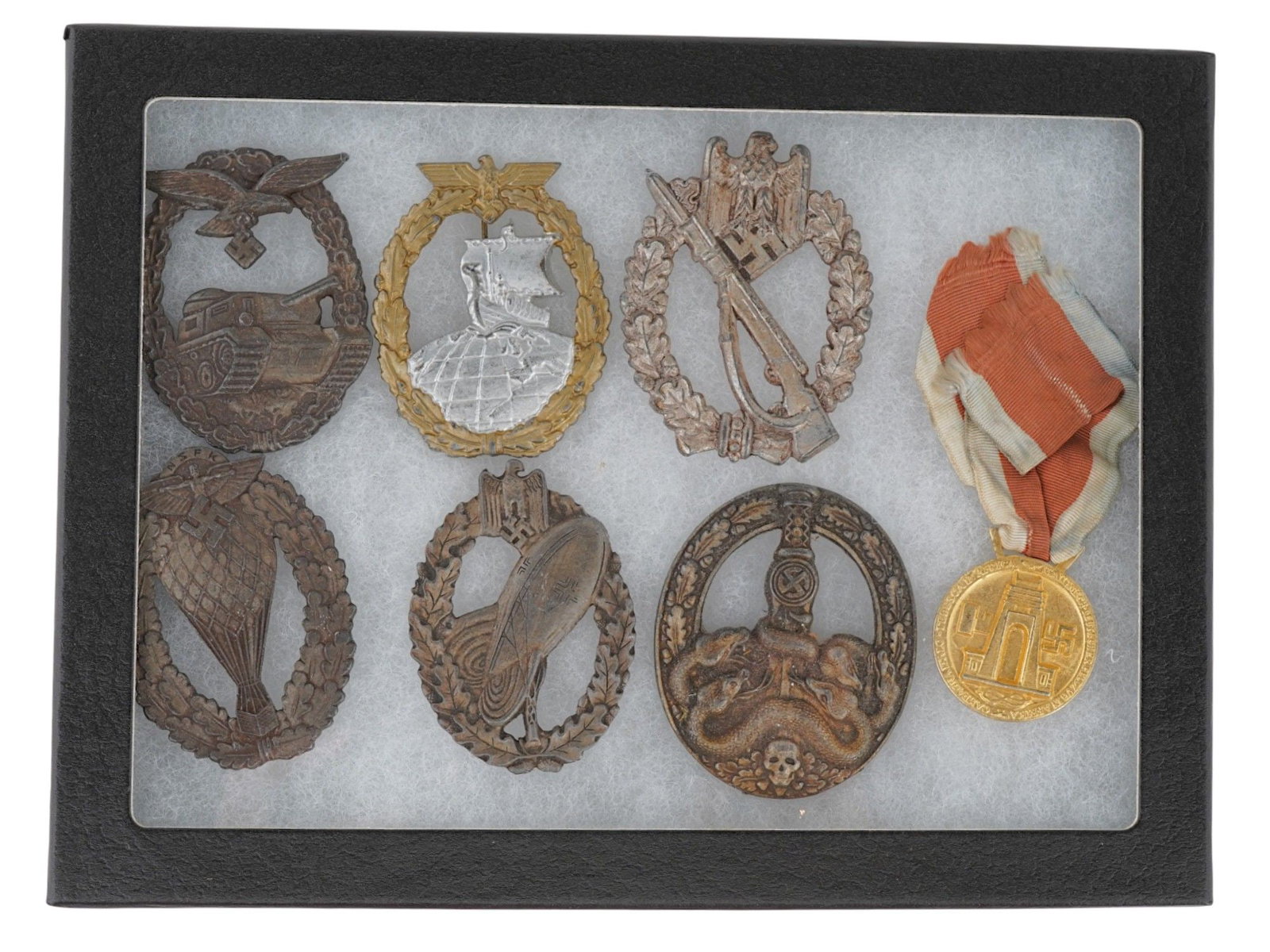 GROUP OF 7 GERMAN WWII AWARD BADGES: A lot of 7 Nazi German military decorations. Luftwaffe Tank Assault, Kriegsmarine Auxiliary Cruiser, Infantry Assault, NSFK Balloon Pilot, Balloon Observer, Anti-Partisan badge, Commemorative medal of