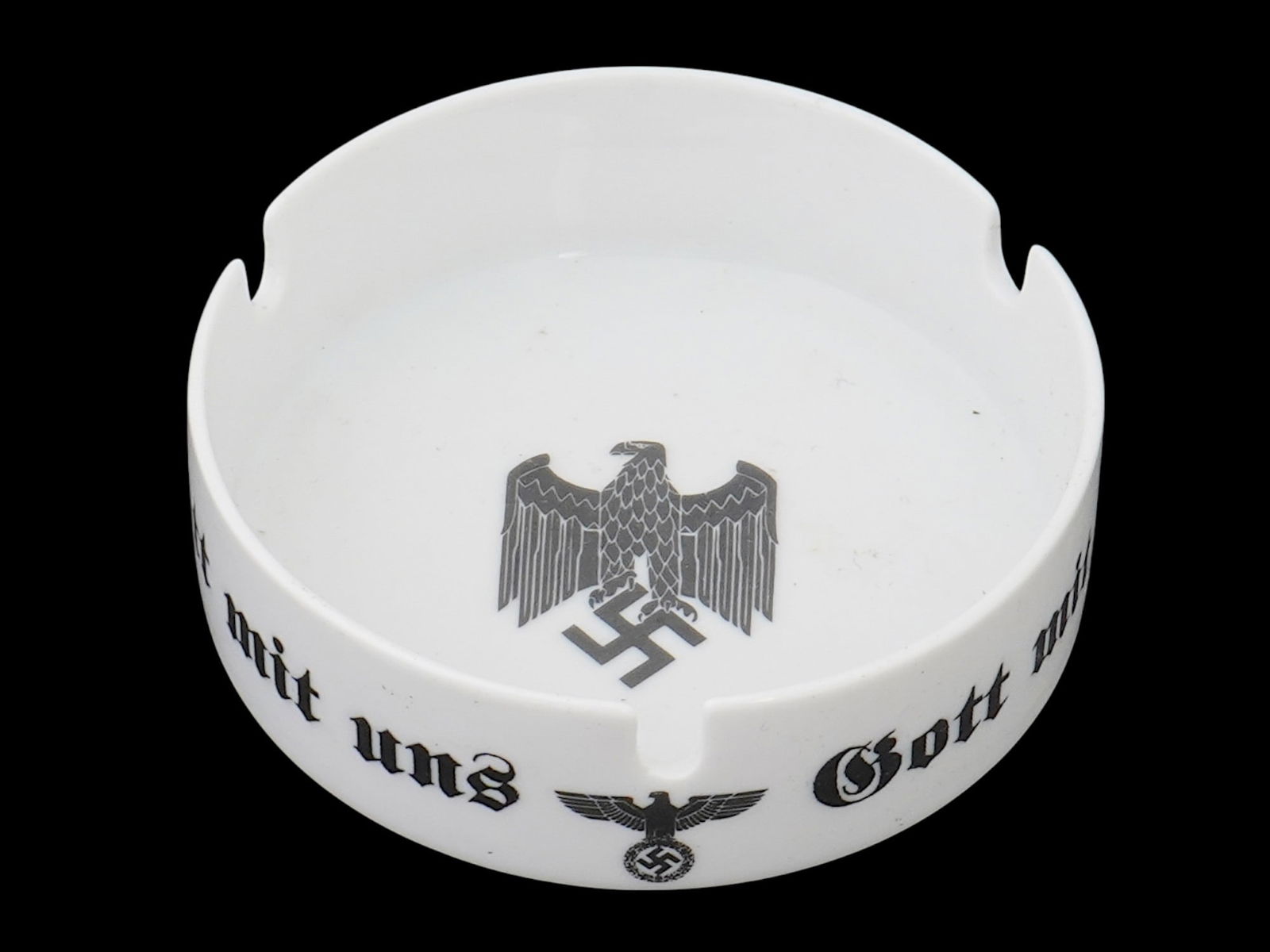 WWII MODEL NAZI GERMAN EAGLE CERAMIC ASHTRAY MARKED: A WWII model Nazi German white ceramic ashtray by Heinrich Porzellan. The exterior of the ashtray is adorned with a transfer printed decor representing a Reichsadler nazi eagle clutching a swastika in