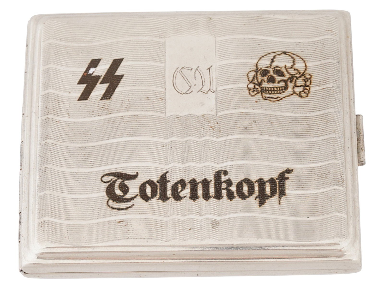 GERMAN WWII MODEL WAFFEN SS DIVISION CIGARETTE CASE: A World War II model Nazi German steel cigarette case with hinged lid. The surface is adorned with a ribbed design and decorated with niello engraved designs representing SS runes, a Totenkopf skull a