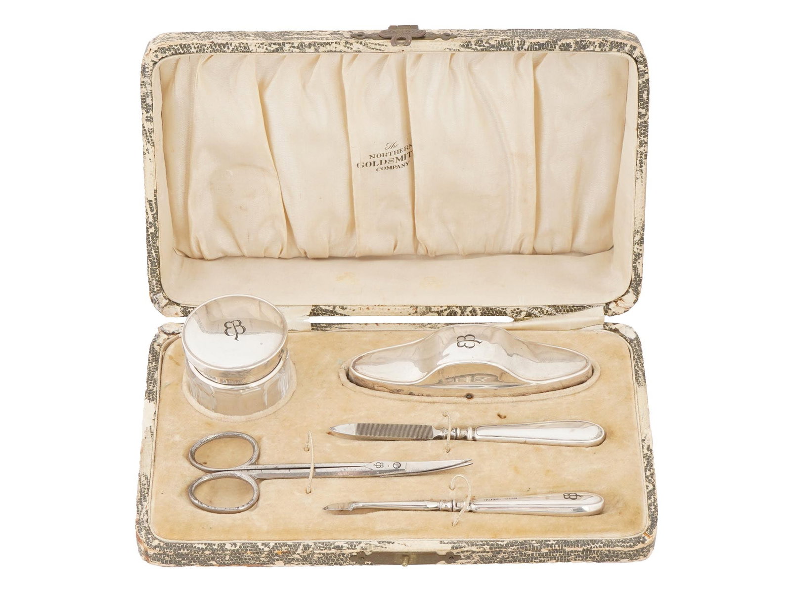 WWII TYPE EVA BRAUN MONOGRAMMED SILVER MANICURE SET: An English sterling silver manicure set. The set includes a pair of manicure scissors, a trimmer, a polissoir, a nail file, and a cream box. Each item is garnished with engraved initials EB referring 