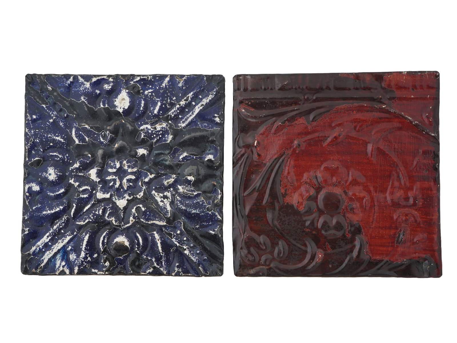 PAIR OF FLORAL AND FOLIAGE ENAMEL ON TIN PLAQUES: A pair of rectangular shaped enamel tin plaques. The plaques depicts relief floral and foliage ornaments and covered with enamel in blue and red shades. One is stamped on the backside. Vintage and Mid