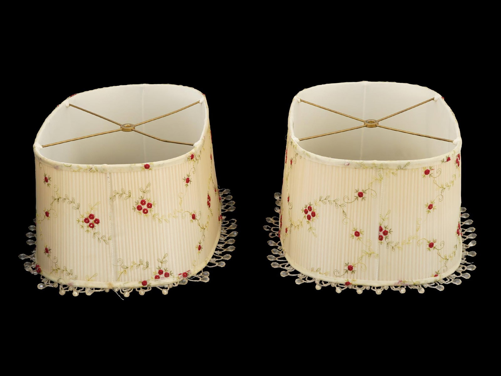 PAIR OF FLORAL EMBROIDERED LAMP SHADOWS BY ROSEART: A pair of embroidered lamp shadow. The shadows feature an embroidered pattern of floral and foliage motifs. The wares are decorated with hanging drop beads to the edges. Marked with a label, Custom Ta