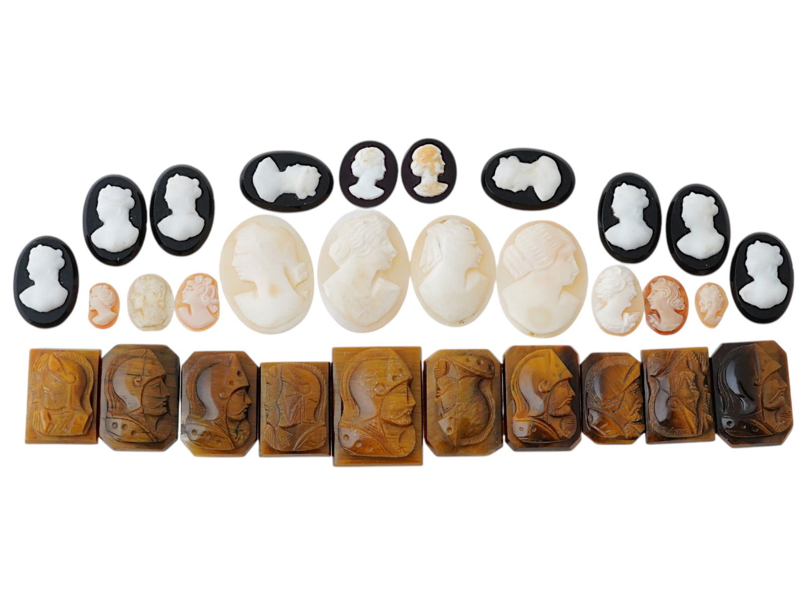 COLLECTION OF ANTIQUE HAND CARVED CAMEOS: A collection of antique hand carved cameos, dating to the late 19th to early 20th century. Each piece is crafted from conch shell and stone, featuring knights in armor and female portraits rendered in