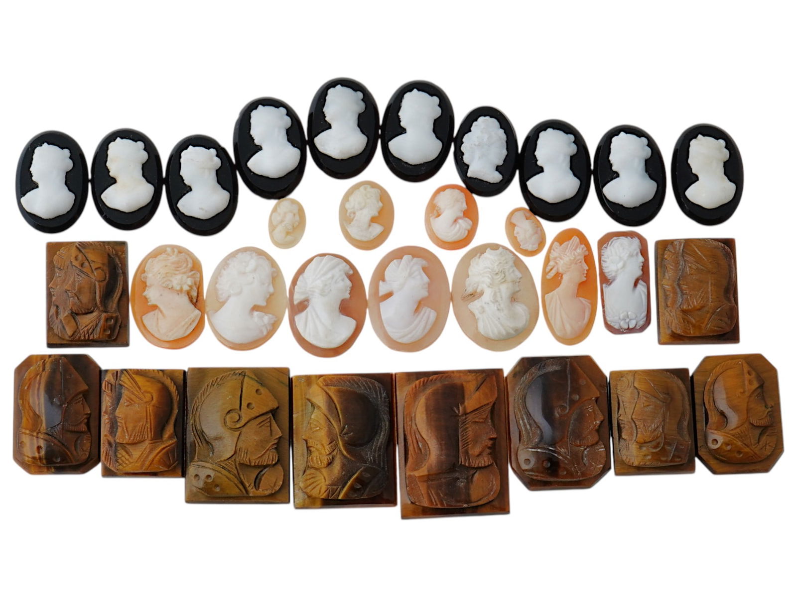 COLLECTION OF ANTIQUE HAND CARVED CAMEOS: A collection of antique hand carved cameos, dating to the late 19th to early 20th century. Each piece is crafted from conch shell and stone, featuring knights in armor and female portraits rendered in