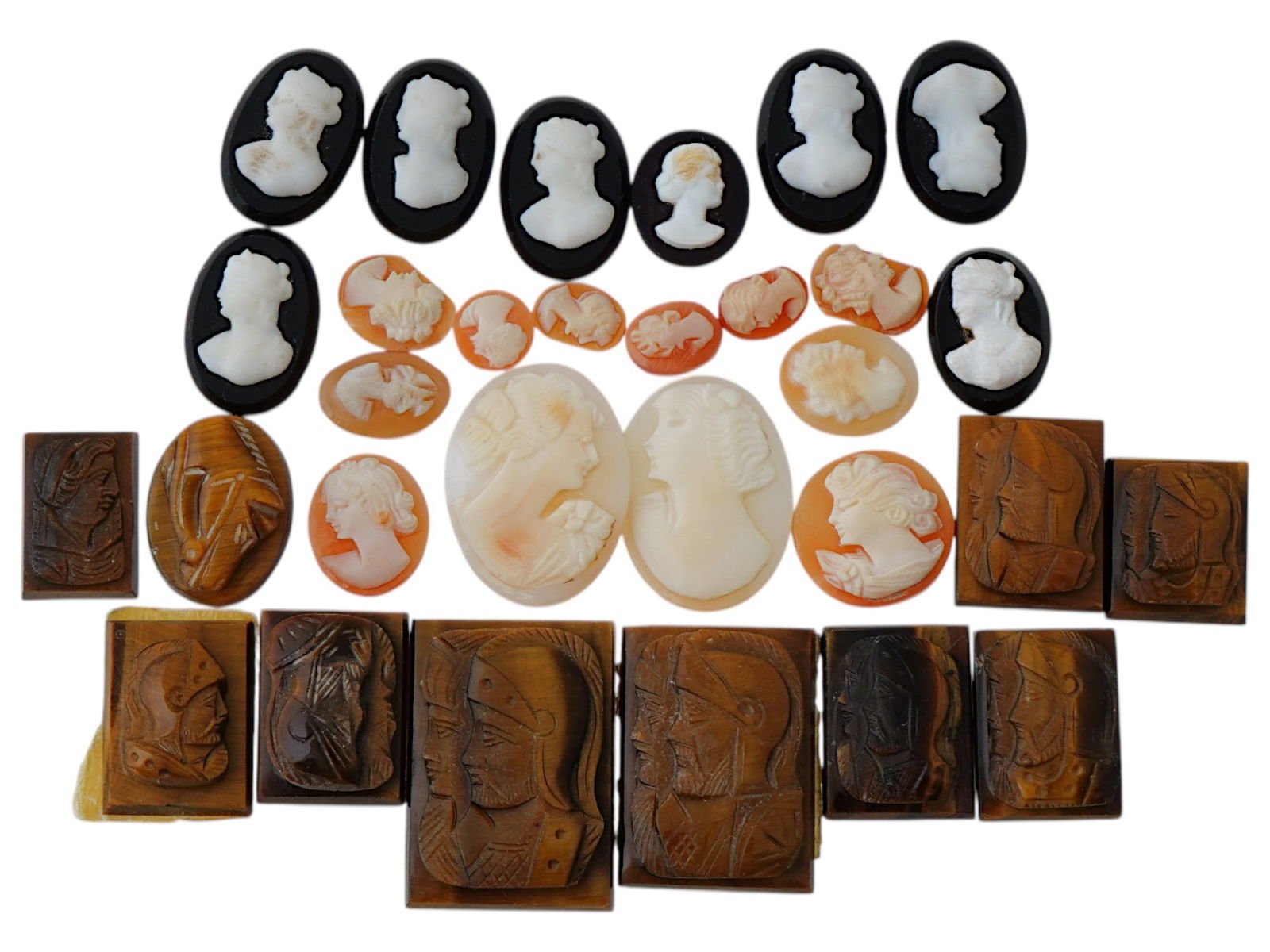 COLLECTION OF ANTIQUE HAND CARVED CAMEOS: A collection of antique hand carved cameos, dating to the late 19th to early 20th century. Each piece is crafted from conch shell and stone, featuring knights in armor and female portraits rendered in