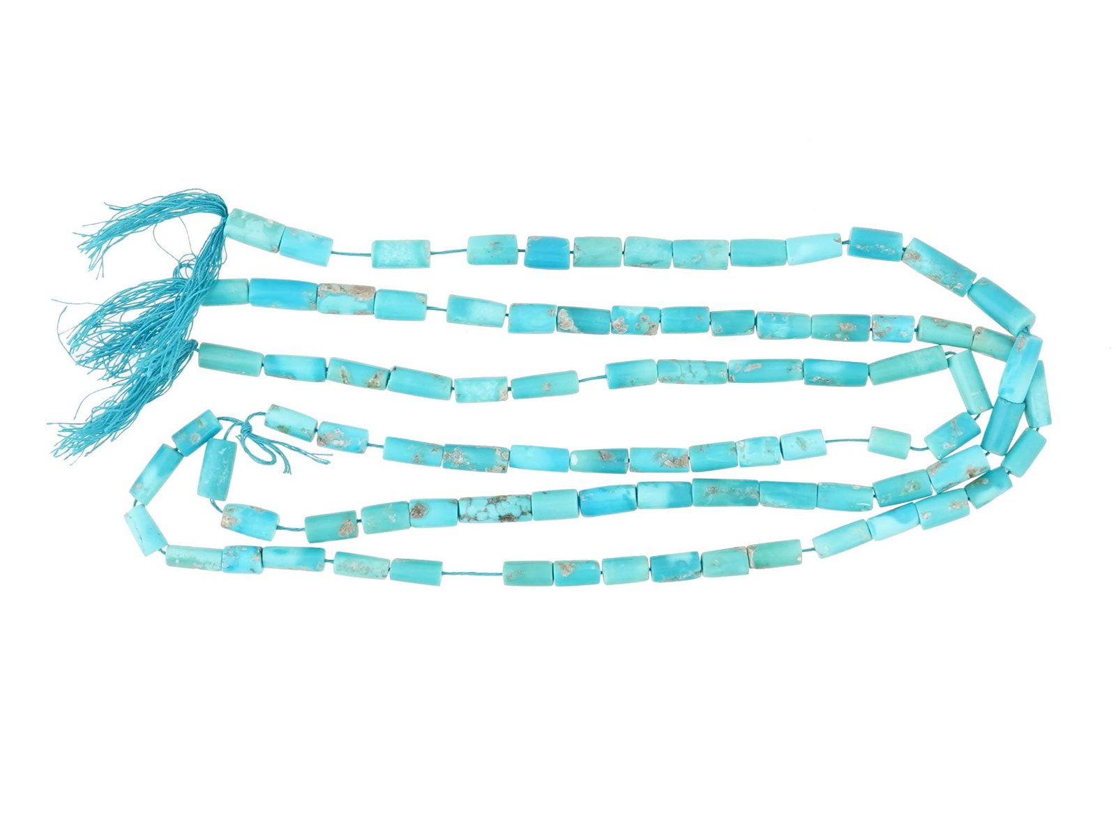 SET OF TURQUOISE BEADS OF TUBULAR SHAPE FOR NECKLACE: A collection of turquoise beads of tubular shape, strung on cords, ready to be crafted into a necklace. The beads exhibit the vibrant blue and green hues typical of turquoise, along with unique natura