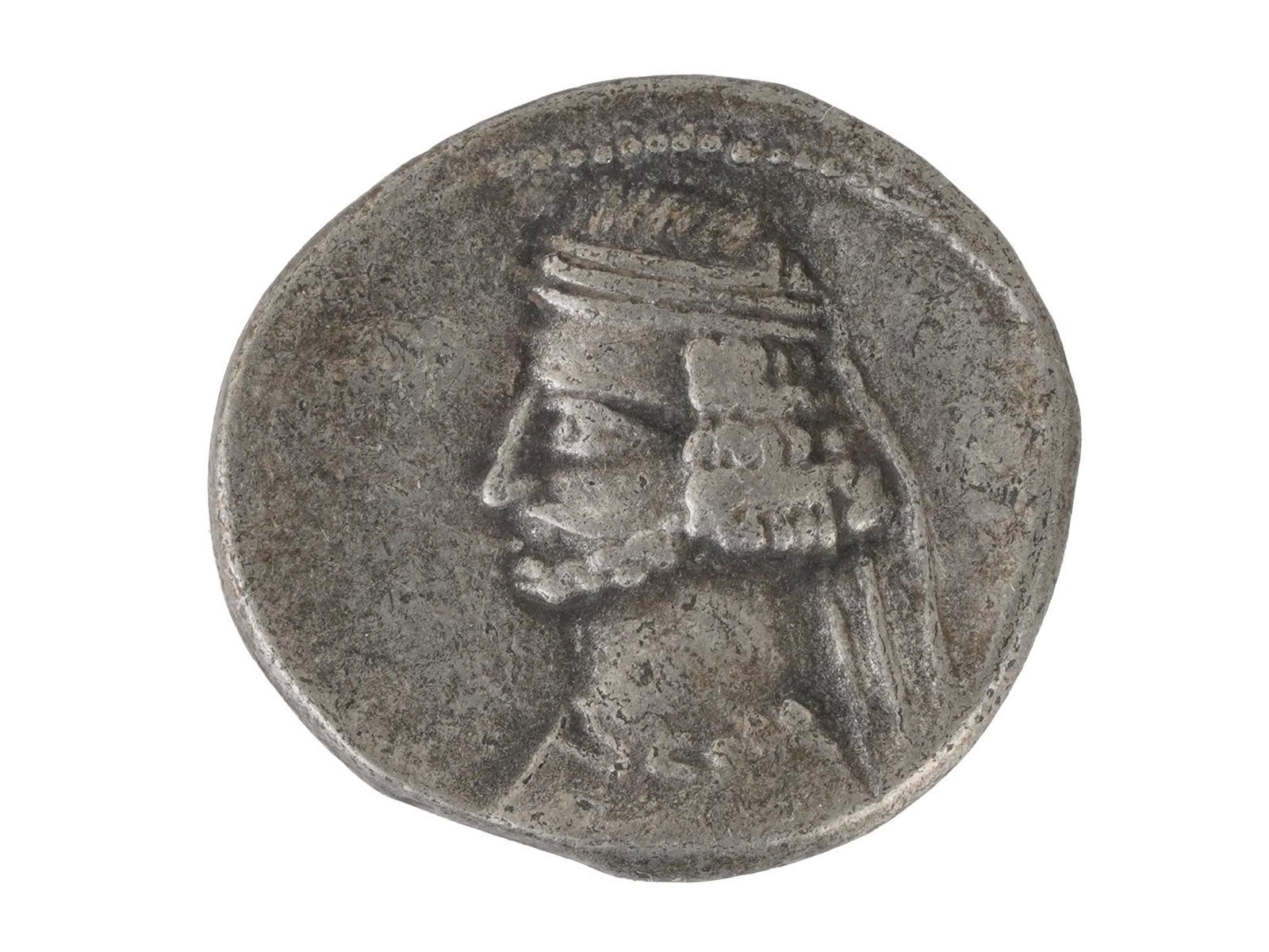 ANCIENT PERSIAN PARITHIAN ORODES II SILVER DRACHM COIN: An ancient Persian Parithian Empire, Orodes II, 57 to 38 BC silver drachm coin with a portrait of the ruler on the obverse. The reverse features a seated archer and Greek inscriptions. Ancient Persian