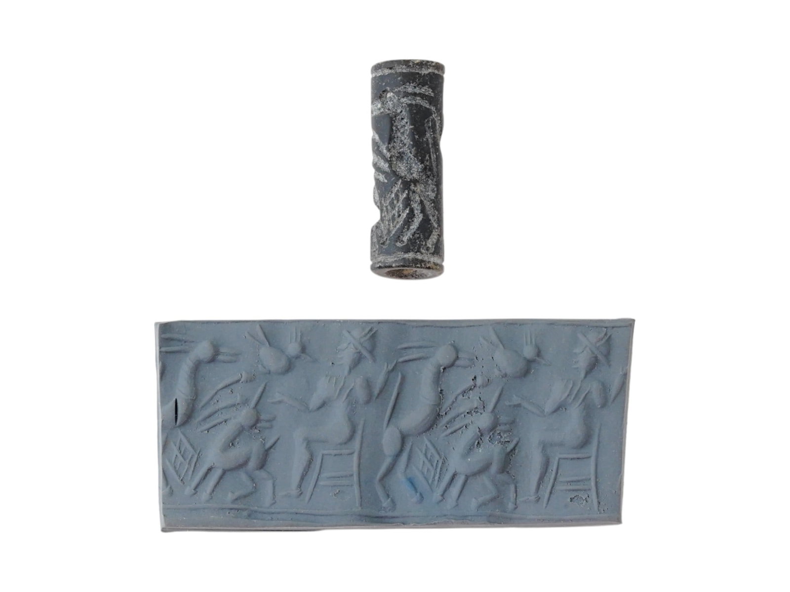 ANCIENT SYRIAN STONE CYLINDER SEAL ANIMALS AND RULER: An ancient Syrian stone cylinder seal, dating to circa 2000 BC, carved with a dynamic scene featuring three animals approaching a seated ruler, likely symbolic of divine or royal authority. The seal i