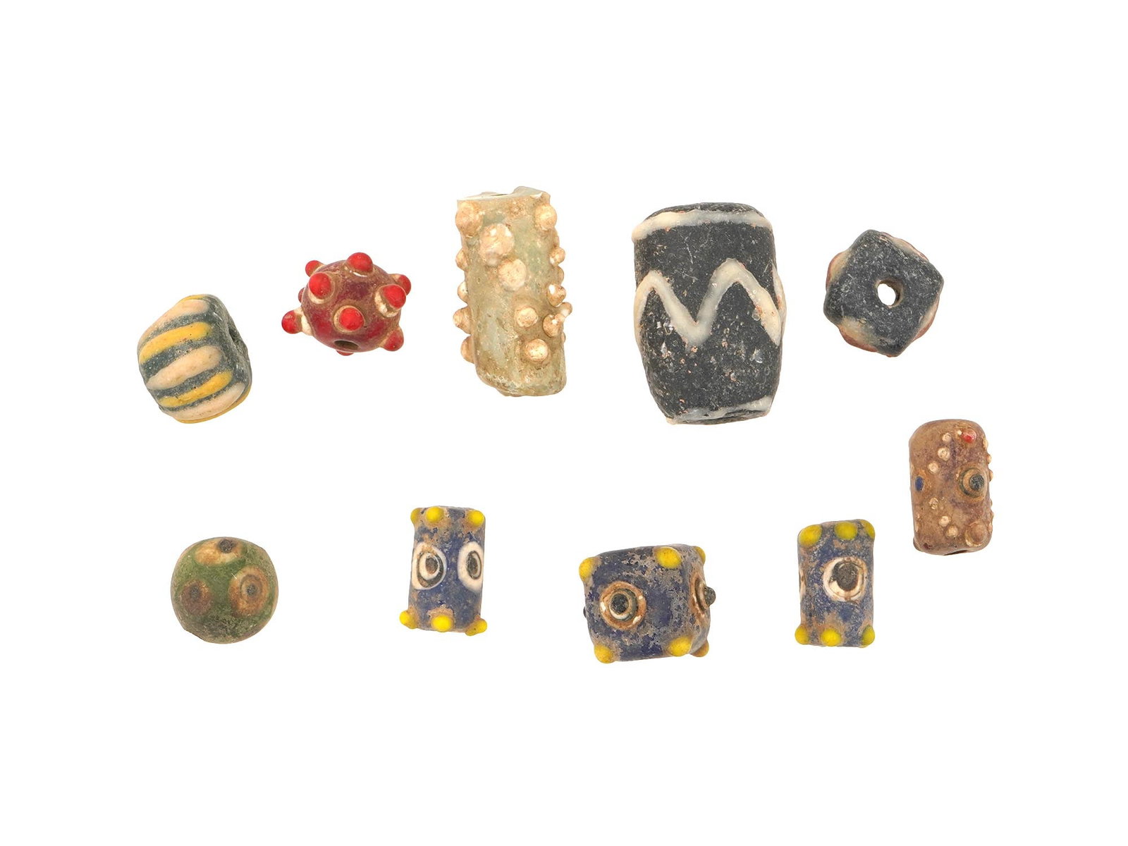 TEN ANCIENT PHOENICIAN GLASS BEADS 500 TO 300 BC: A collection of 10 ancient Phoenician glass beads, dating from 500 to 300 BC, with a variety of shapes, colors, and patterns. The beads showcase the artistry and skill of Phoenician glassmakers, with 