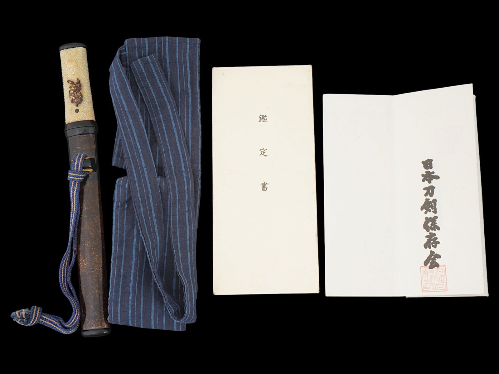 JAPANESE SAMURAI TANTO IN ABALONE LACQUERED CASE: A Japanese Samurai tanto presented in a crushed abalone lacquered case with gold fittings, featuring a signed tang and accompanied by its original Japanese paperwork. The tanto includes its traditiona