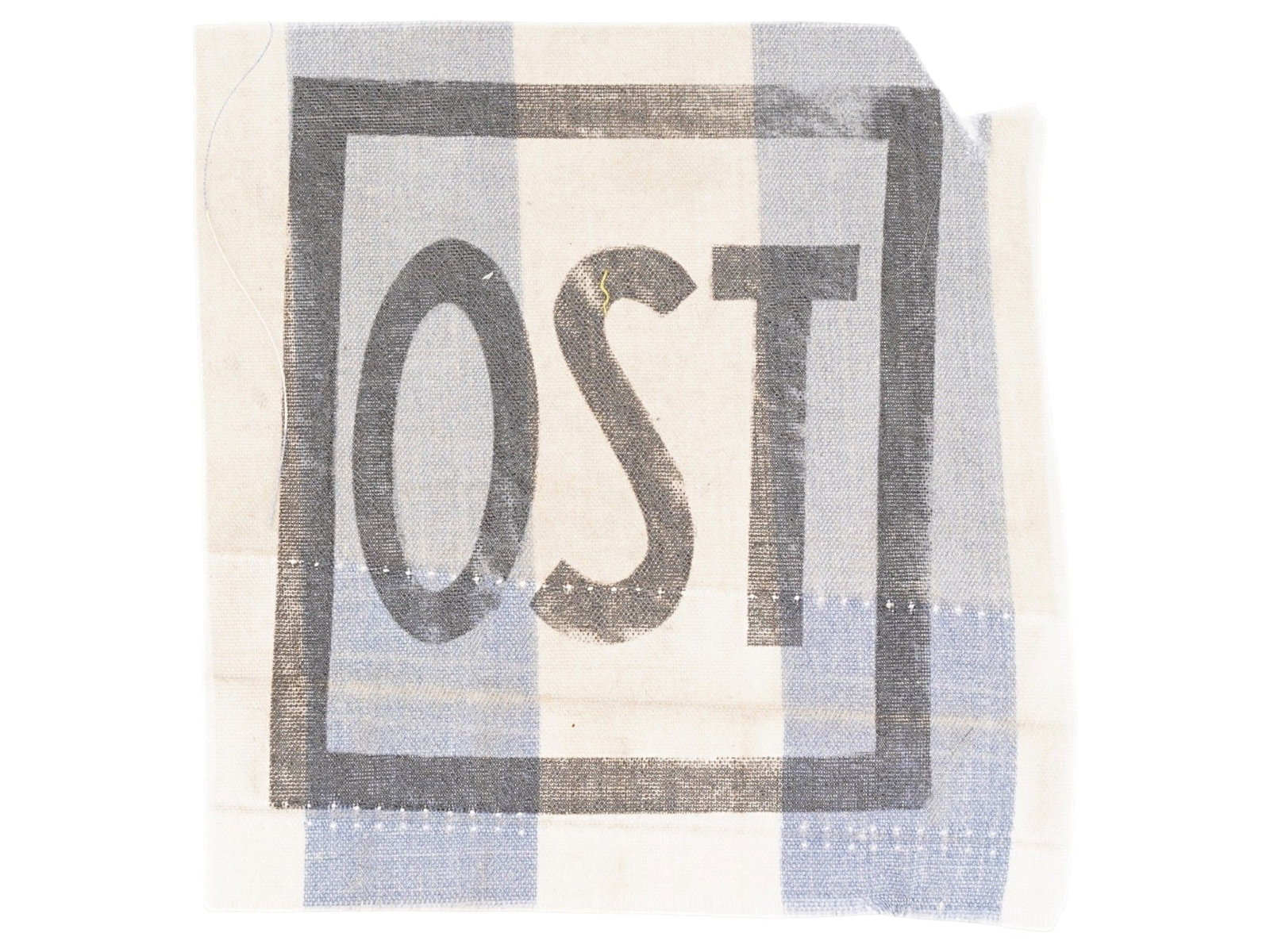 WWII NAZI CONCENTRATION CAMP OST UNIFORM FRAGMENT: A textile fragment from a WWII Nazi German concentration camp uniform bearing the printed OST insignia, which identified individuals from Eastern Europe forced into labor under Nazi occupation. Second