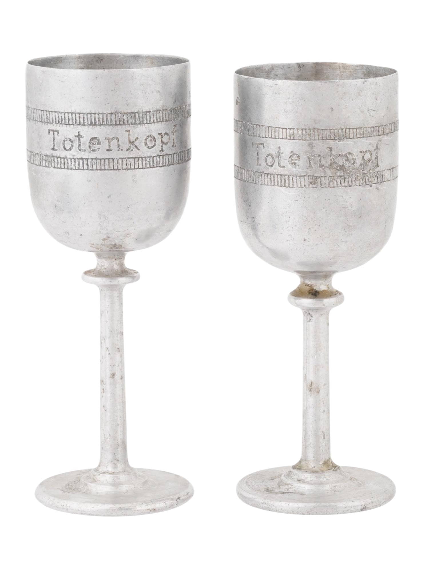 GERMAN WWII TYPE WAFFEN SS SCHNAPPS VODKA CUPS SET: A set of two WWII type Nazi German footed schnapps vodka cups for Waffen SS Totenkopf Battle for Demyansk. Engraved with an inscription, Totenkopf, and Demjansk, dated 1941, and a Totenkopf skull symb