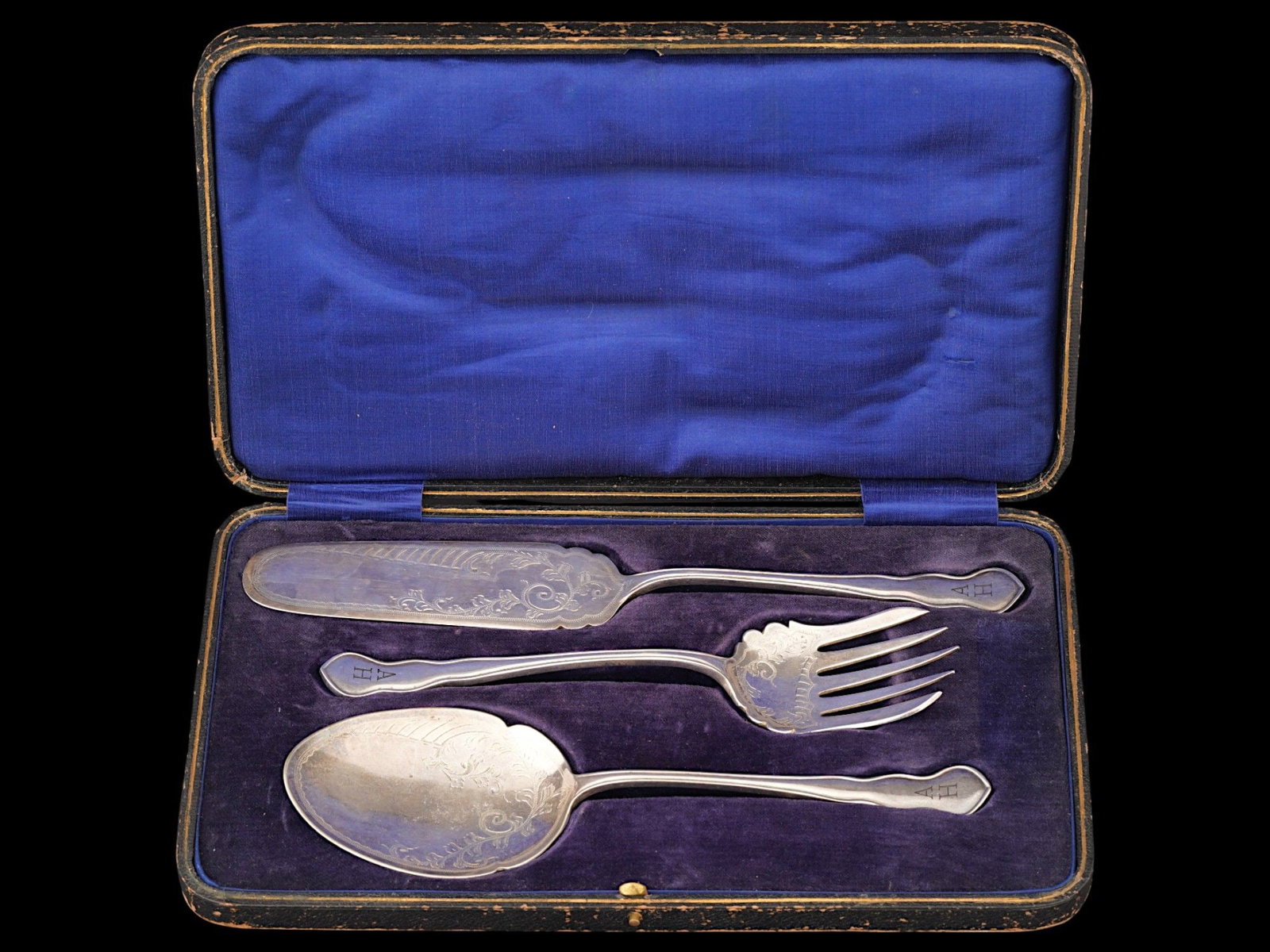 ADOLF HITLER ENGLISH SILVER PLATED DESSERT CUTLERY: A mid-20th century English silver-plated dessert serving flatware set. A total of 3 items, a knife, a fork, and a spoon. Etched ornamental decor. The tips are engraved with initials AH referring to Ad